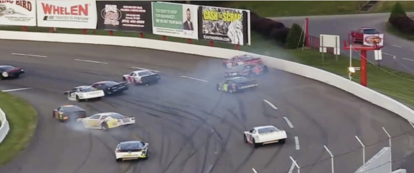 Cars spinning through a cloud of tire smoke, seen from the FloRacing broadcast camera